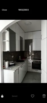 Moderna kuhinja sa bijelim i sivim elementima i ugrađenom tehnikom. - image 2