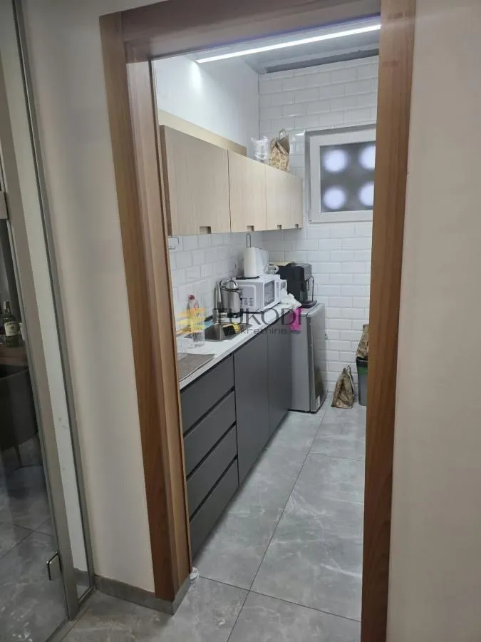 View of a small modernly equipped kitchen through the doorway.