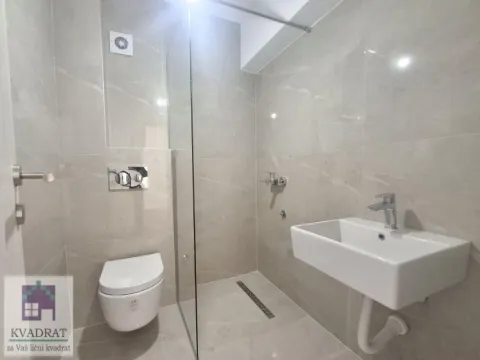 Modern bathroom with a walk-in shower, washbasin, and wall-hung toilet tiled with light-colored tiles. - image 14