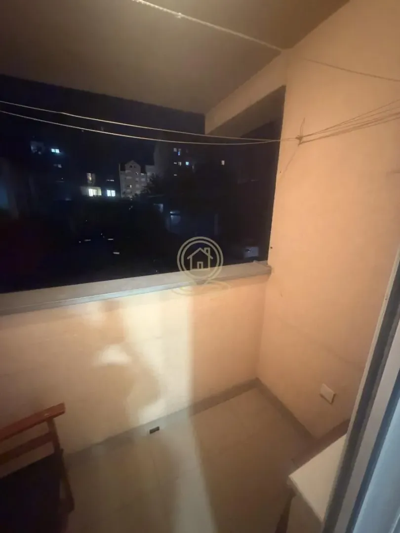 Smaller enclosed balcony with a night view.