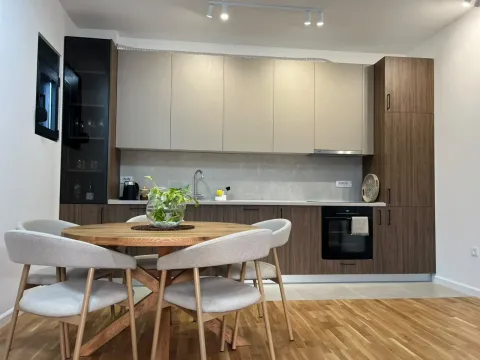 Modern kitchen with a dining table and built-in appliances. - image 4