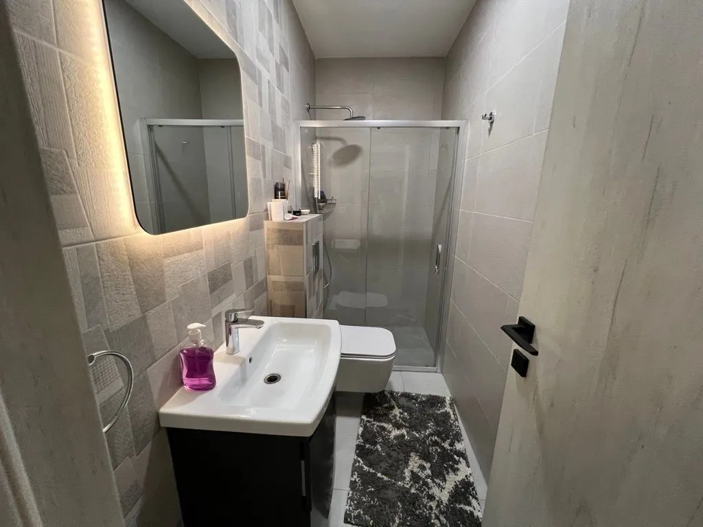 Modernly equipped bathroom with a shower cabin and sink.