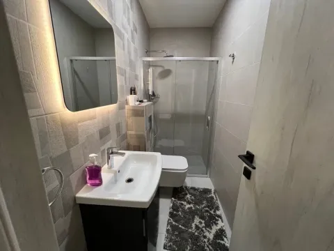 Modernly equipped bathroom with a shower cabin and sink. - image 4
