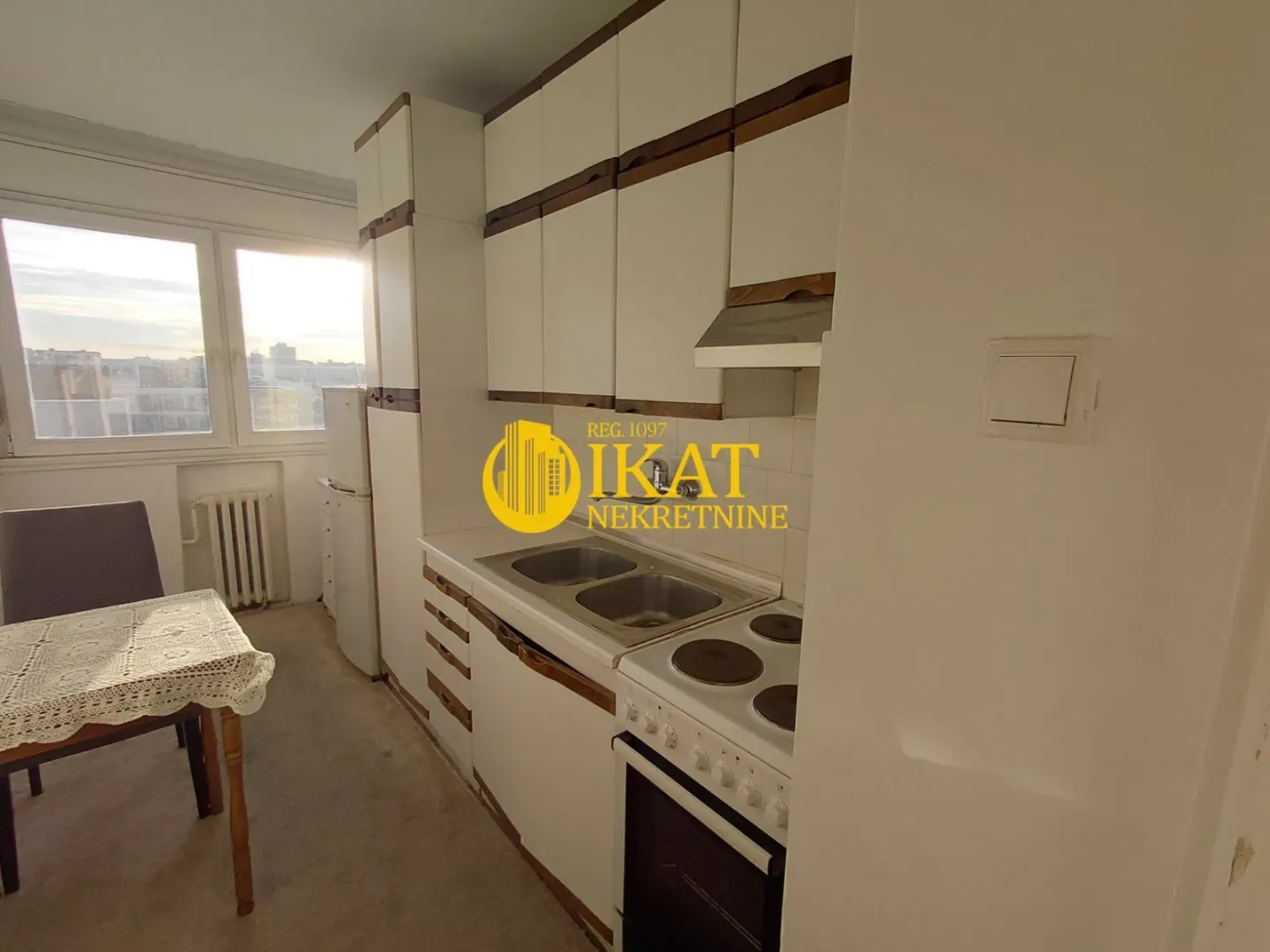 Smaller kitchen with white cabinets and a dining table by the window.