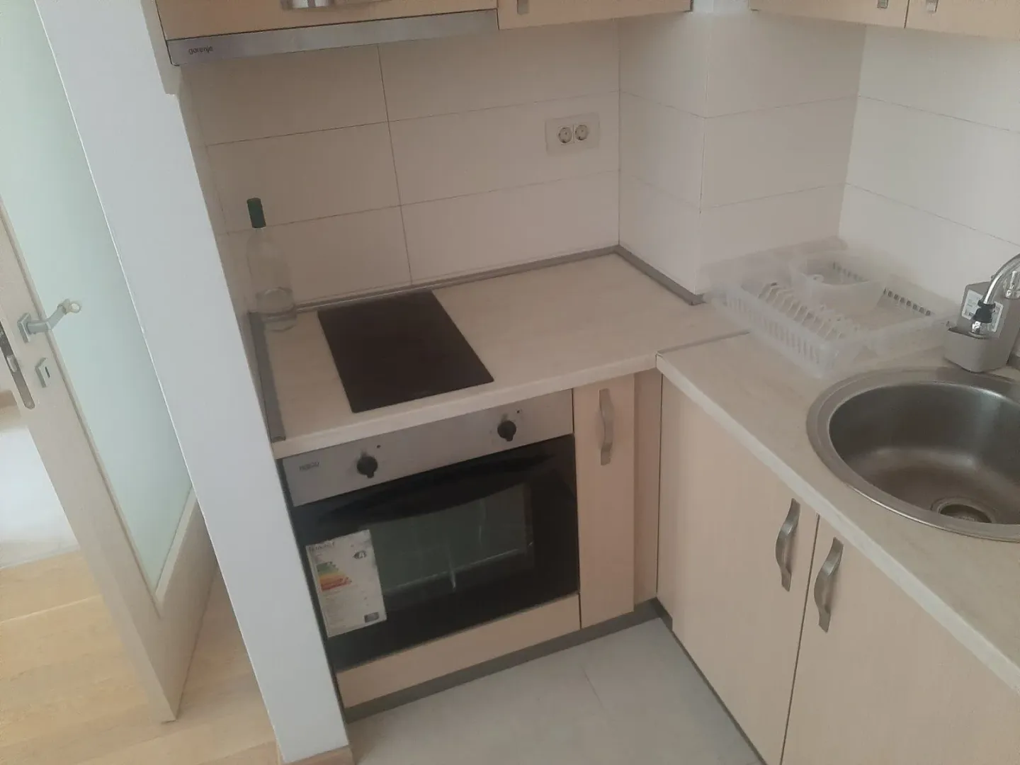 Small kitchen with a built-in oven and a sink.