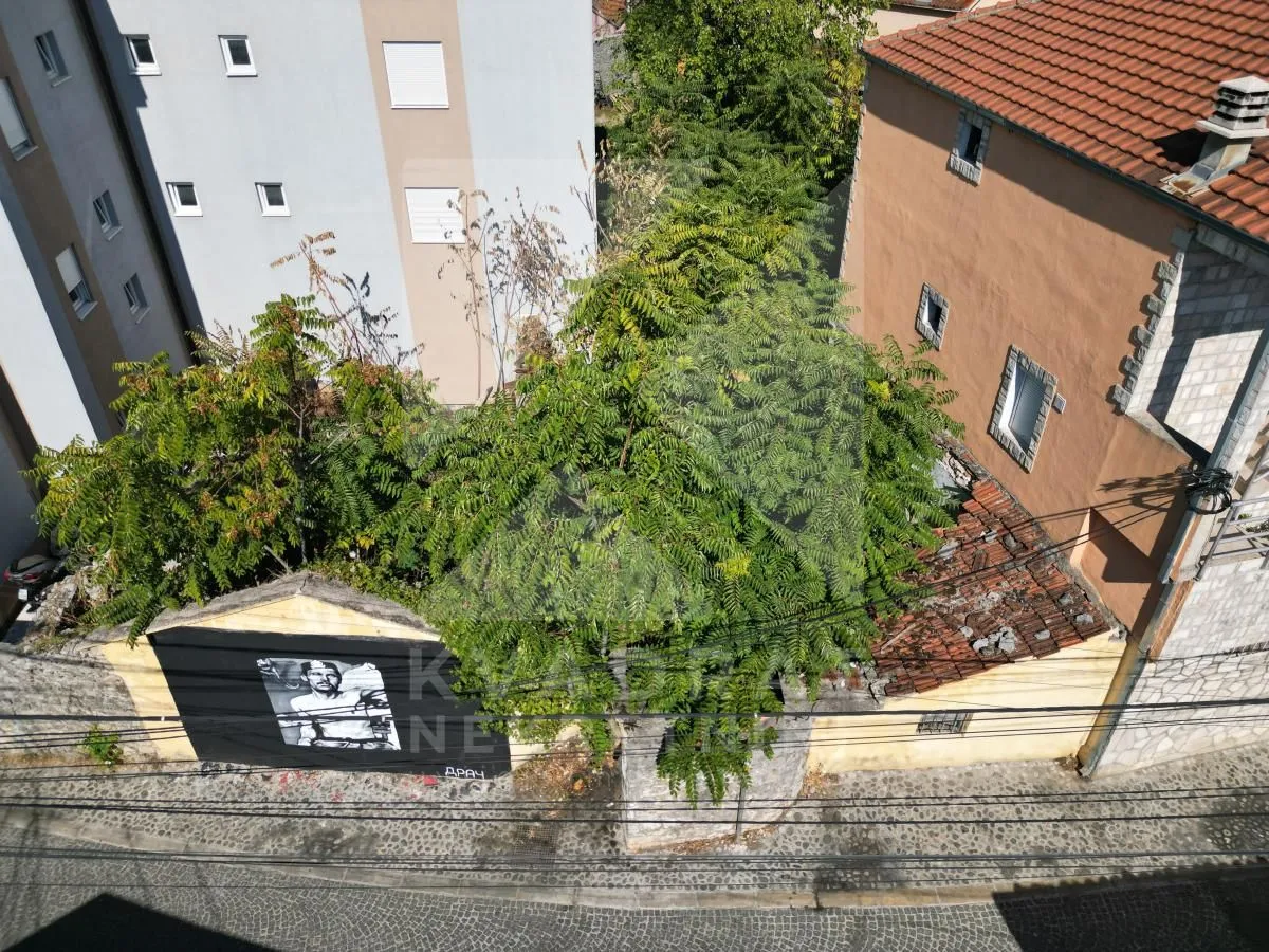 Pogled odozgo na dvorište i okolne objekte u urbanoj sredini.