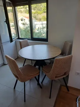 Dining table with four chairs near the window. - image 6