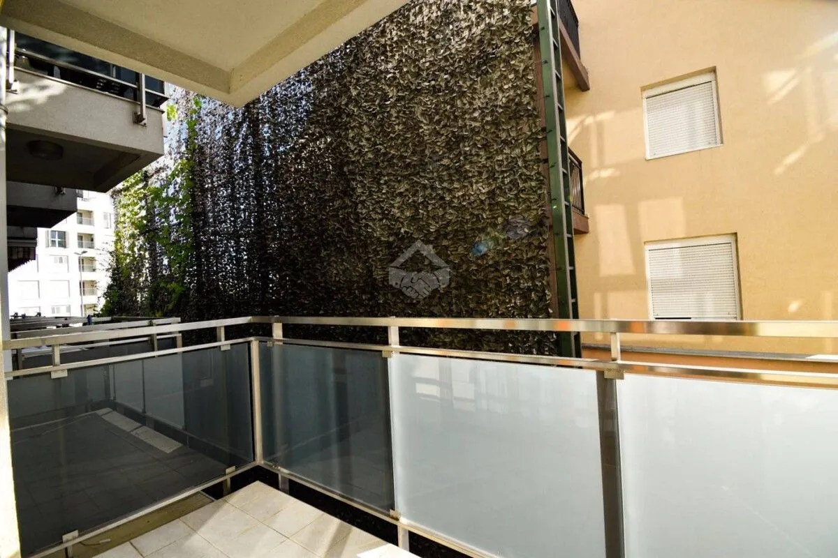 View from the balcony overlooking surrounding buildings and greenery.