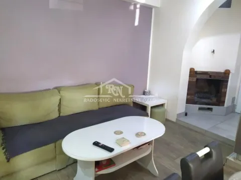 Living room with a sofa, coffee table and a corner fireplace. - image 6