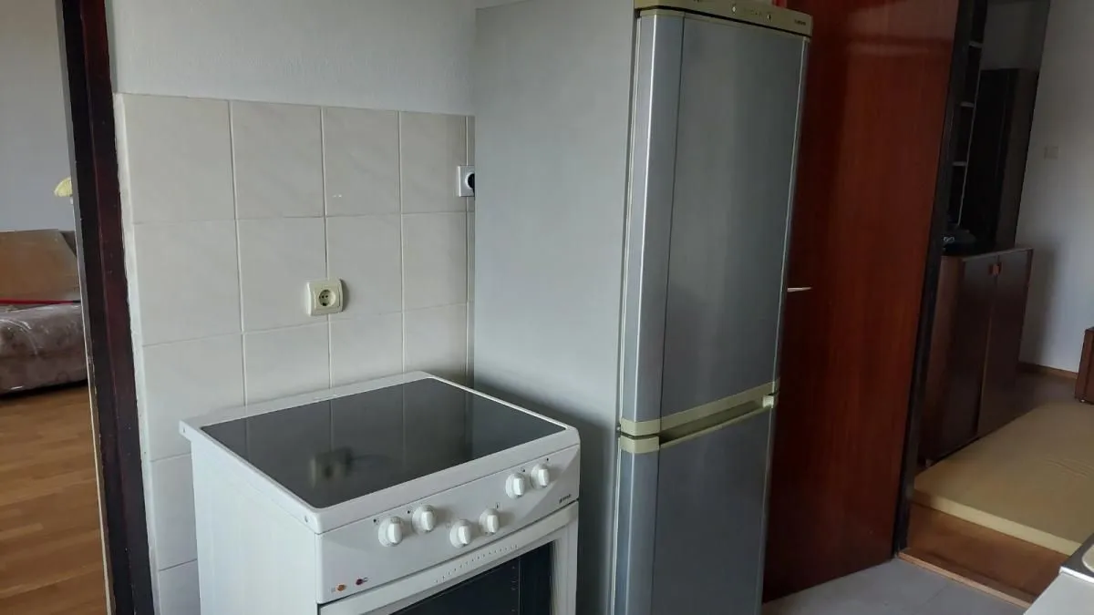 Deo kuhinje sa štednjakom i frižiderom.