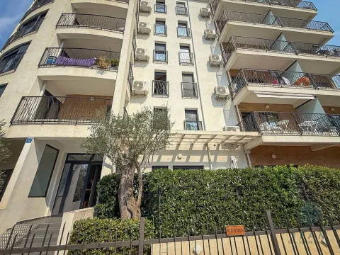 Exterior view of an apartment building with balconies and a landscaped yard. - image 11