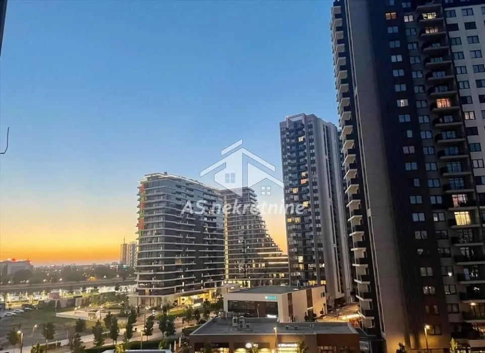 View from the window overlooking surrounding modern buildings and the cityscape at dusk.