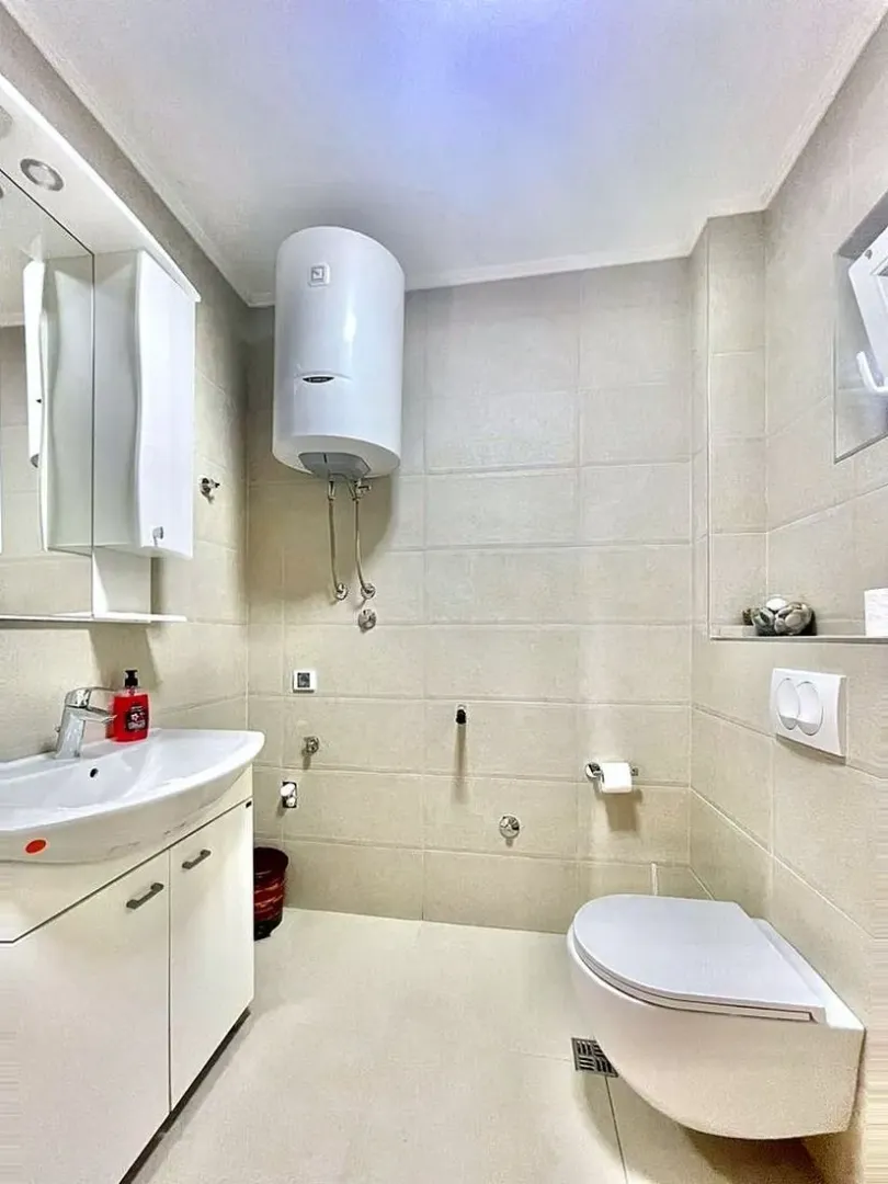 Kupatilo opremljeno umivaonikom, WC šoljom i bojlerom.