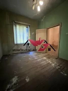 Prazna prostorija sa drvenim podom i prozorom u stanju za renoviranje. - image 9
