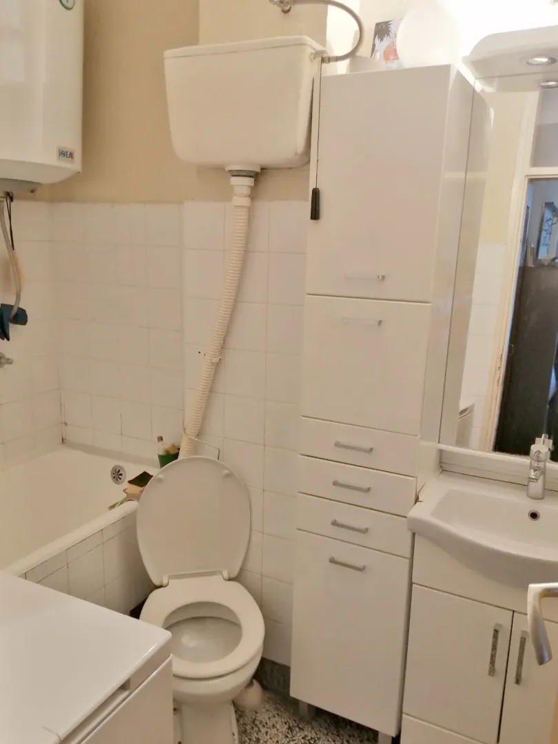 Kupatilo sa kadom, toaletom i bijelim ormarićima.
