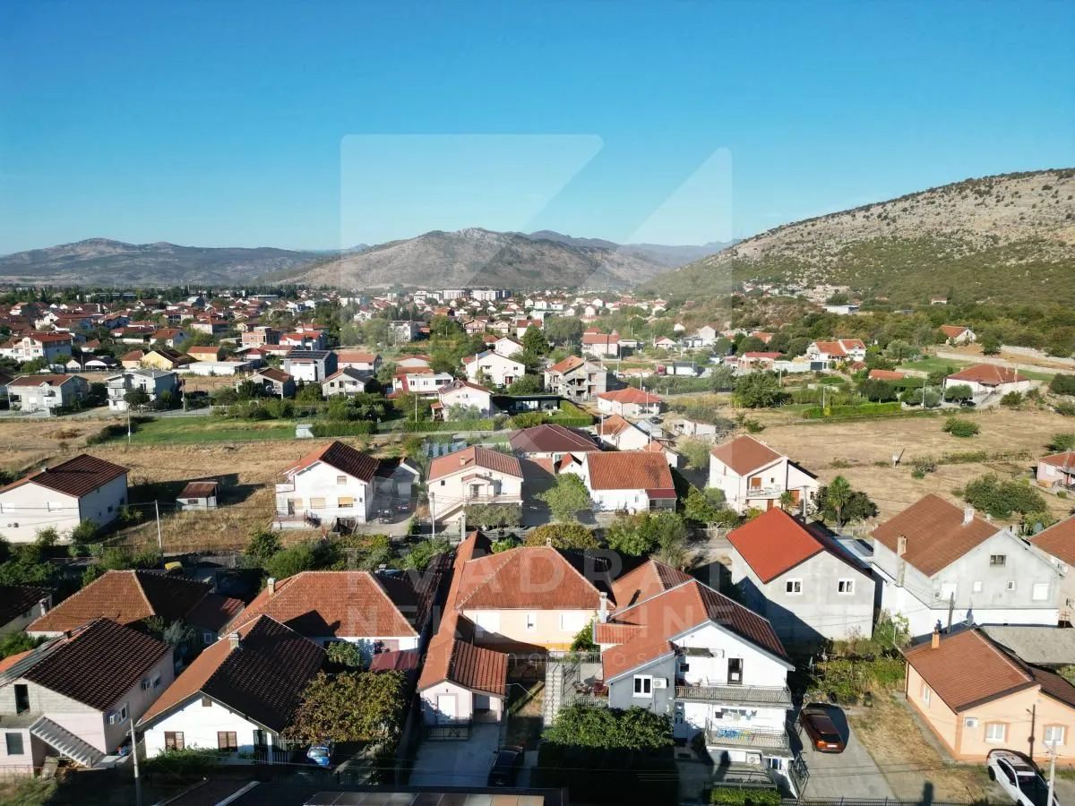 Pogled iz vazduha na naselje i okolne planine.