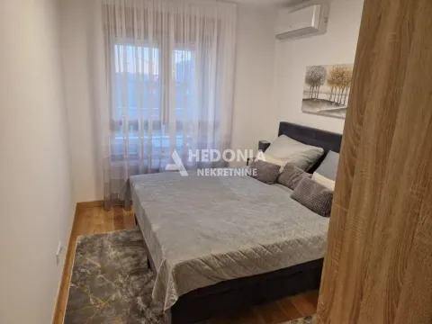 Furnished bedroom with a double bed, window, and air conditioning unit. - image 9
