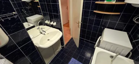 Kupatilo sa umivaonikom, kadom i tamnim pločicama na zidovima. - image 10