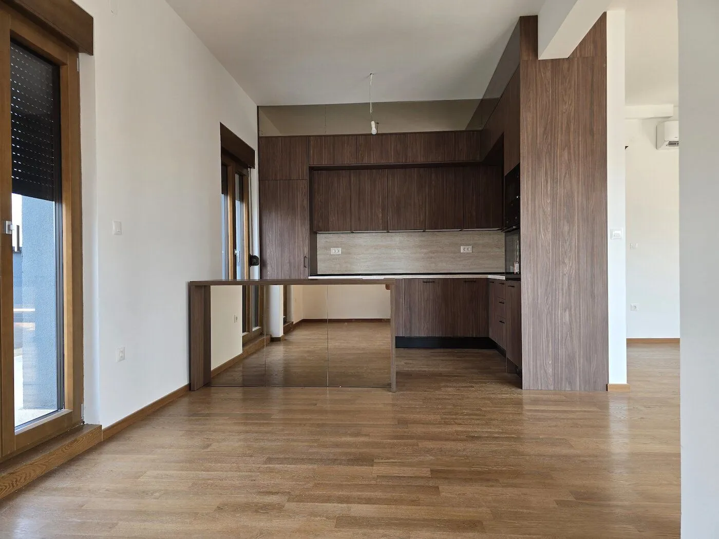 Modern kitchen with wooden elements and parquet flooring.