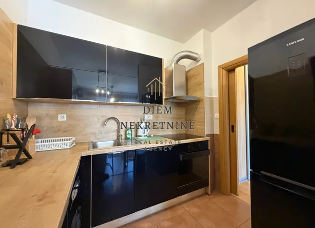 Modern kitchen with dark cabinets and wooden details.