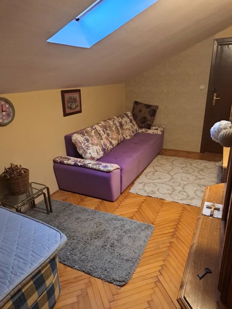 Potkrovlje sa garniturom za sjedenje i krovnim prozorom.