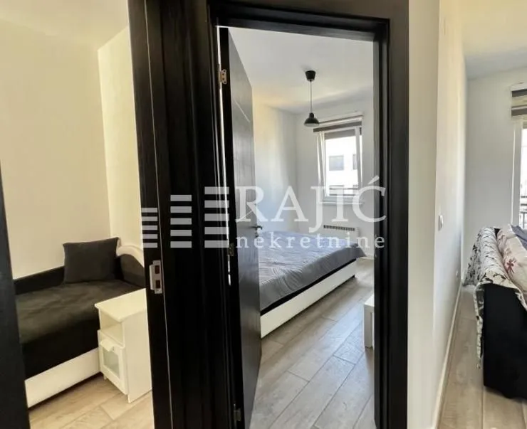 View from the hallway into the bedroom with a double bed.