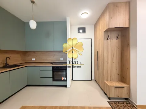 Modern green kitchen with wooden elements and a built-in hallway wardrobe. - image 7