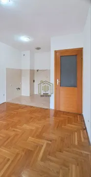 Prazna kuhinja sa parketom na podu i drvenim vratima. - image 4