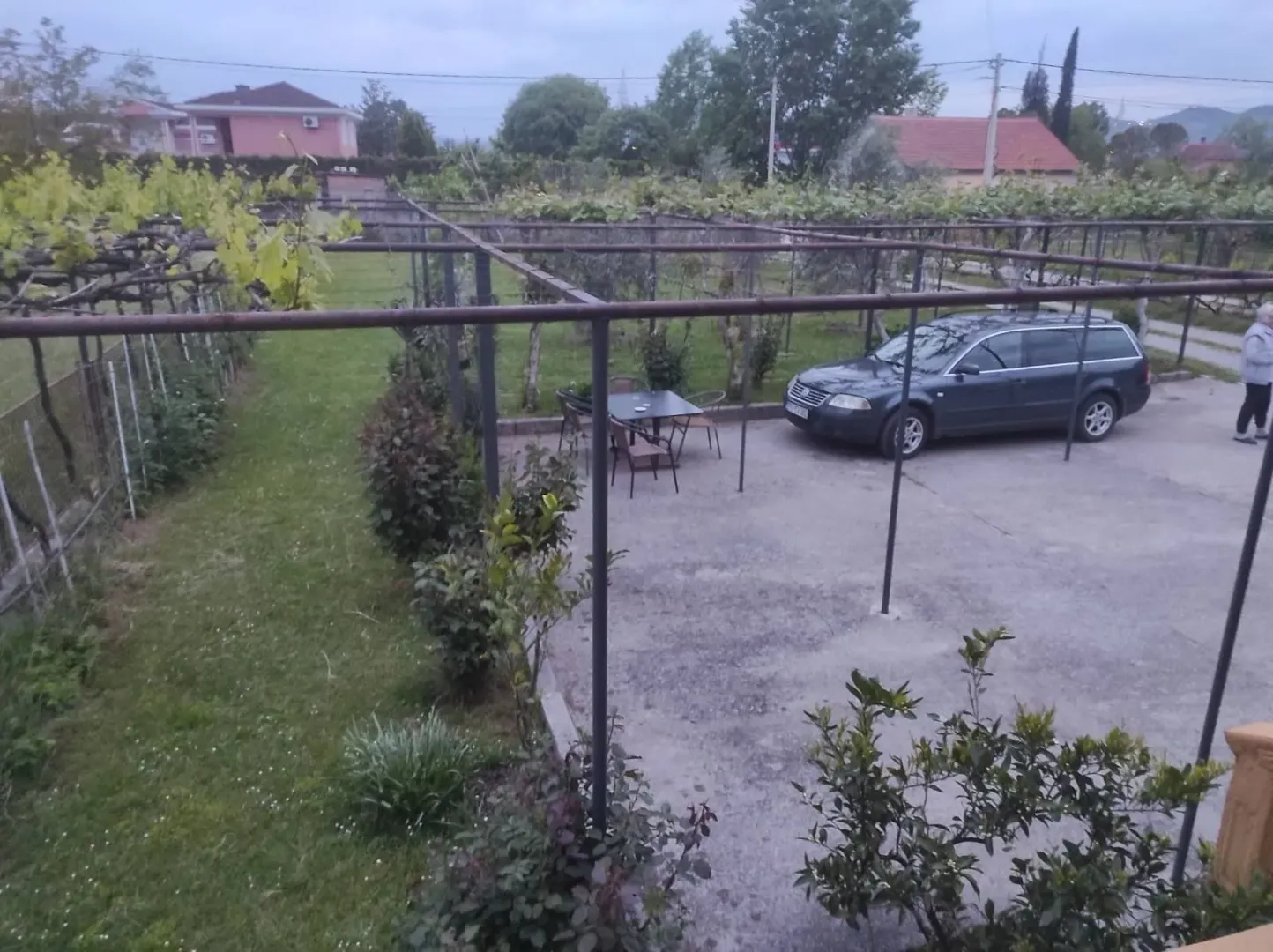 Spacious yard with a paved parking area and landscaped greenery.