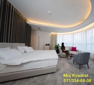 Spacious bedroom with a large double bed and a seating area by the window. - image 6