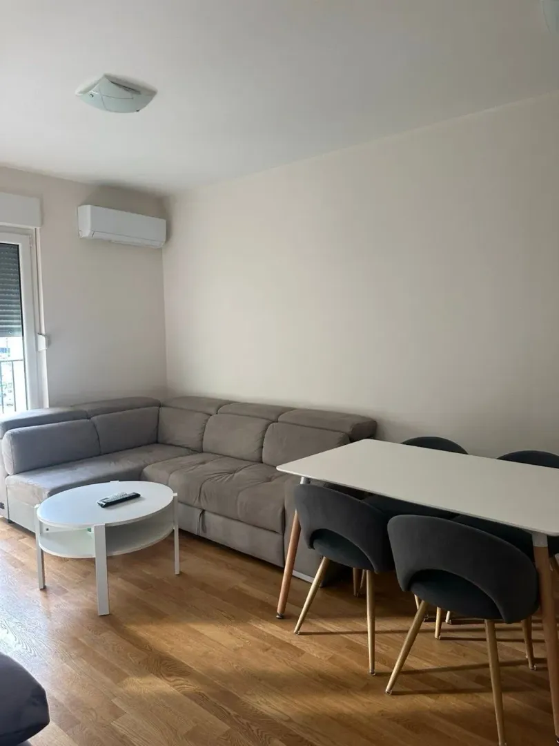 Living room with a sectional sofa, coffee table, and dining table.
