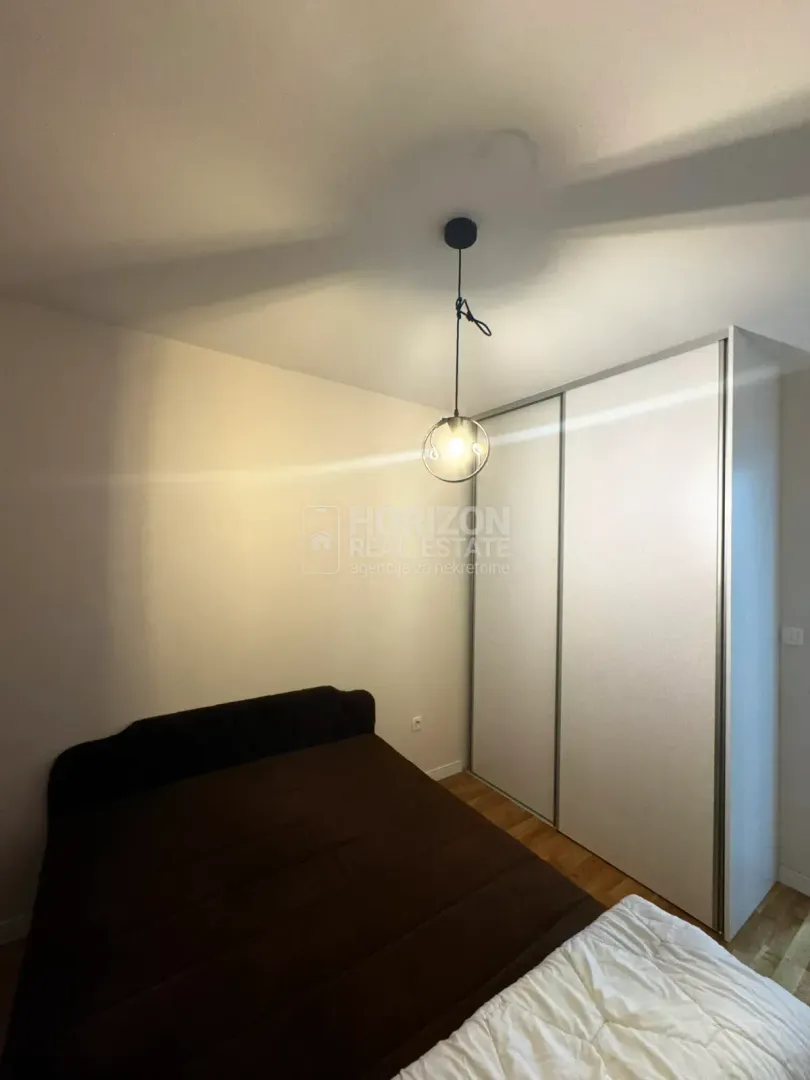Bedroom with a double bed, large wardrobe, and hanging pendant light.