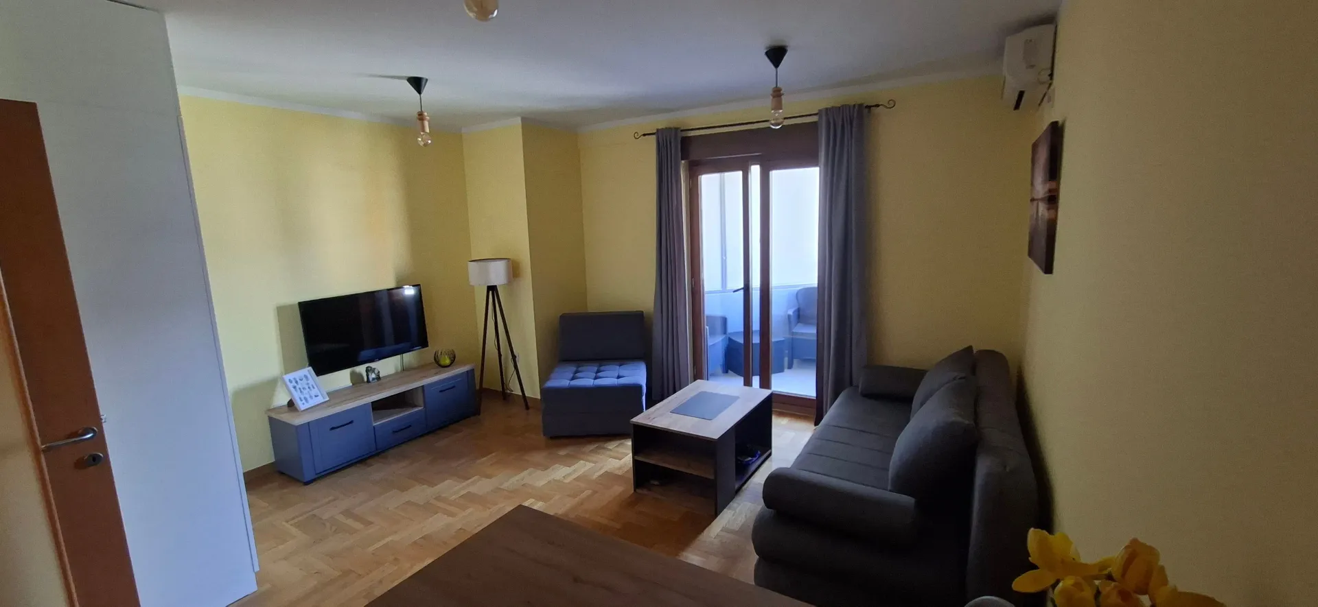 Furnished living room with a sofa, TV, and access to the terrace.