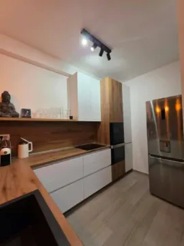 Modern kitchen with white cabinetry, wooden countertops, and built-in appliances. - image 3