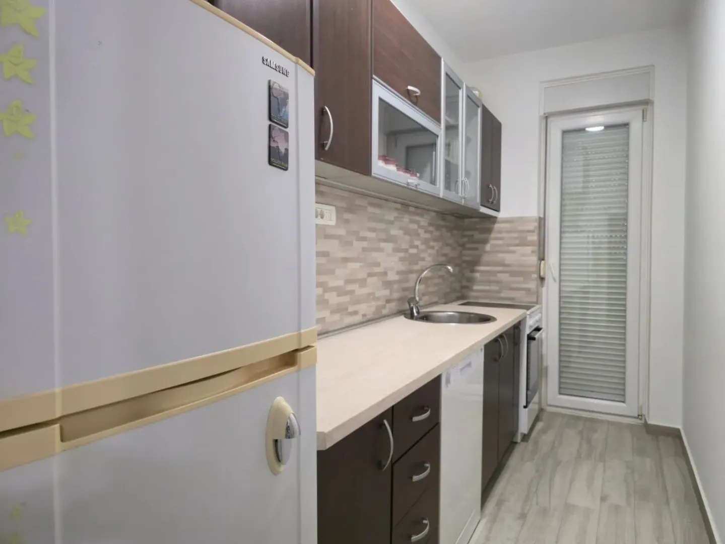 Small kitchen with dark cabinetry and a white refrigerator.