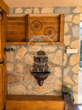 Zid od kamena i drveta sa ukrasnom česmom i drvenim točkovima. - image 30