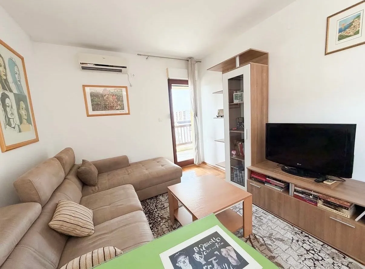 Living room with sofa, TV unit, and access to the terrace.