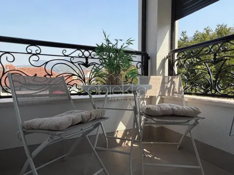 Furnished balcony with a table, chairs, and a decorative plant. - image 4