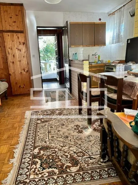 Manja kuhinja sa trpezarijskim stolom i izlazom na terasu.