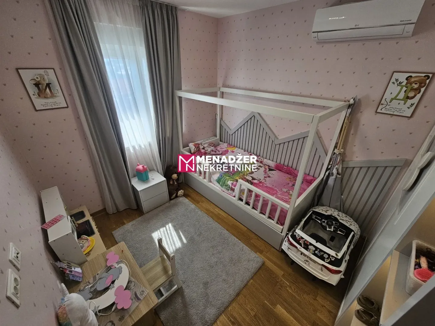 Children's bedroom with a bed, toys, and an air conditioner.