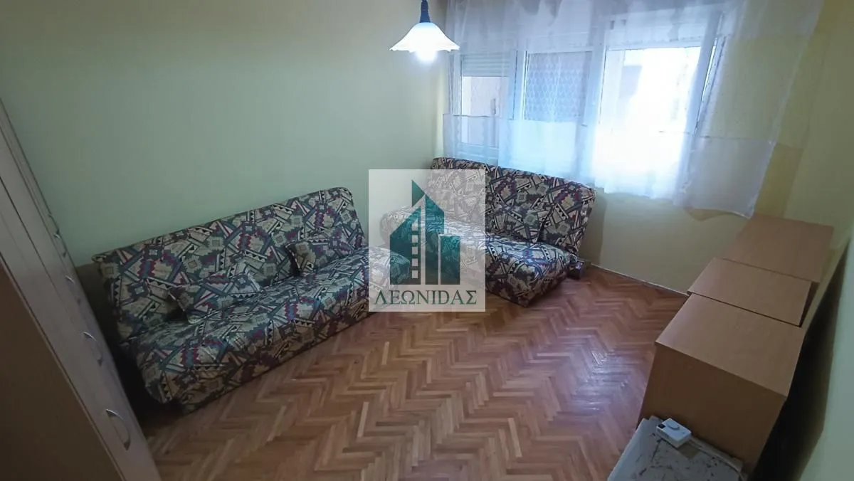 Living room with a sofa and parquet flooring.