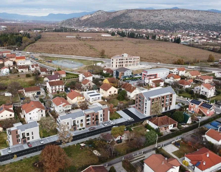 Aerial view of newly constructed residential buildings and the surrounding neighborhood.