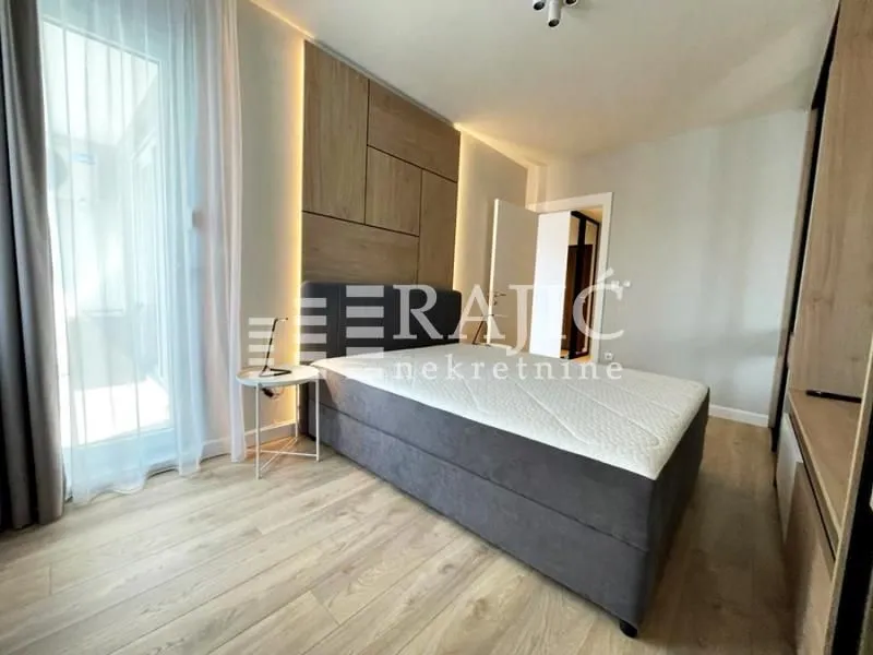 Modern bedroom with a double bed and wooden wall panel.