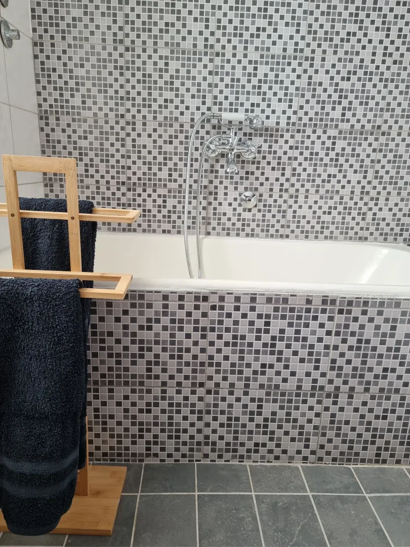 Bathroom with a bathtub and mosaic tiles.