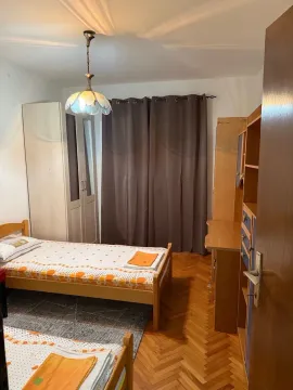 Furnished bedroom with two beds and wooden wardrobes. - image 8