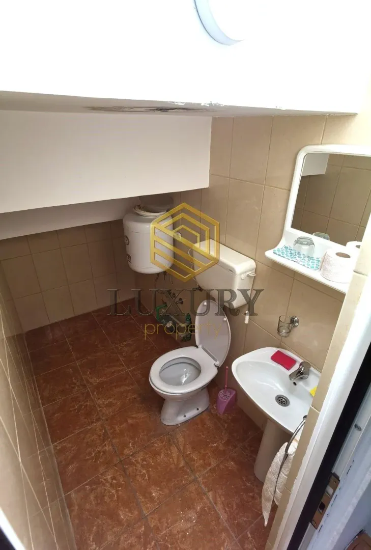 Small bathroom with a toilet, sink, and mirror.