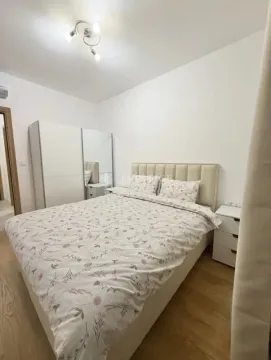 Furnished bedroom with a double bed, white wardrobe, and nightstands. - image 7