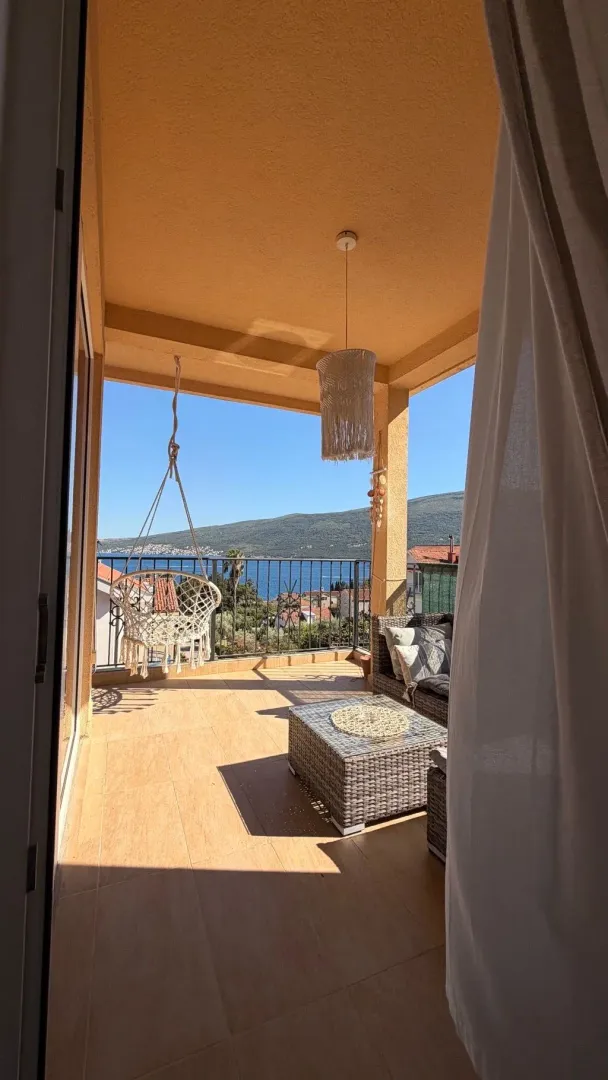 Natkrivena terasa sa garniturom za sjedenje i pogledom na more.