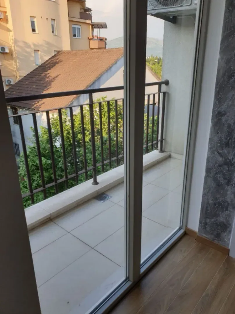 View of a balcony through an open glass door.