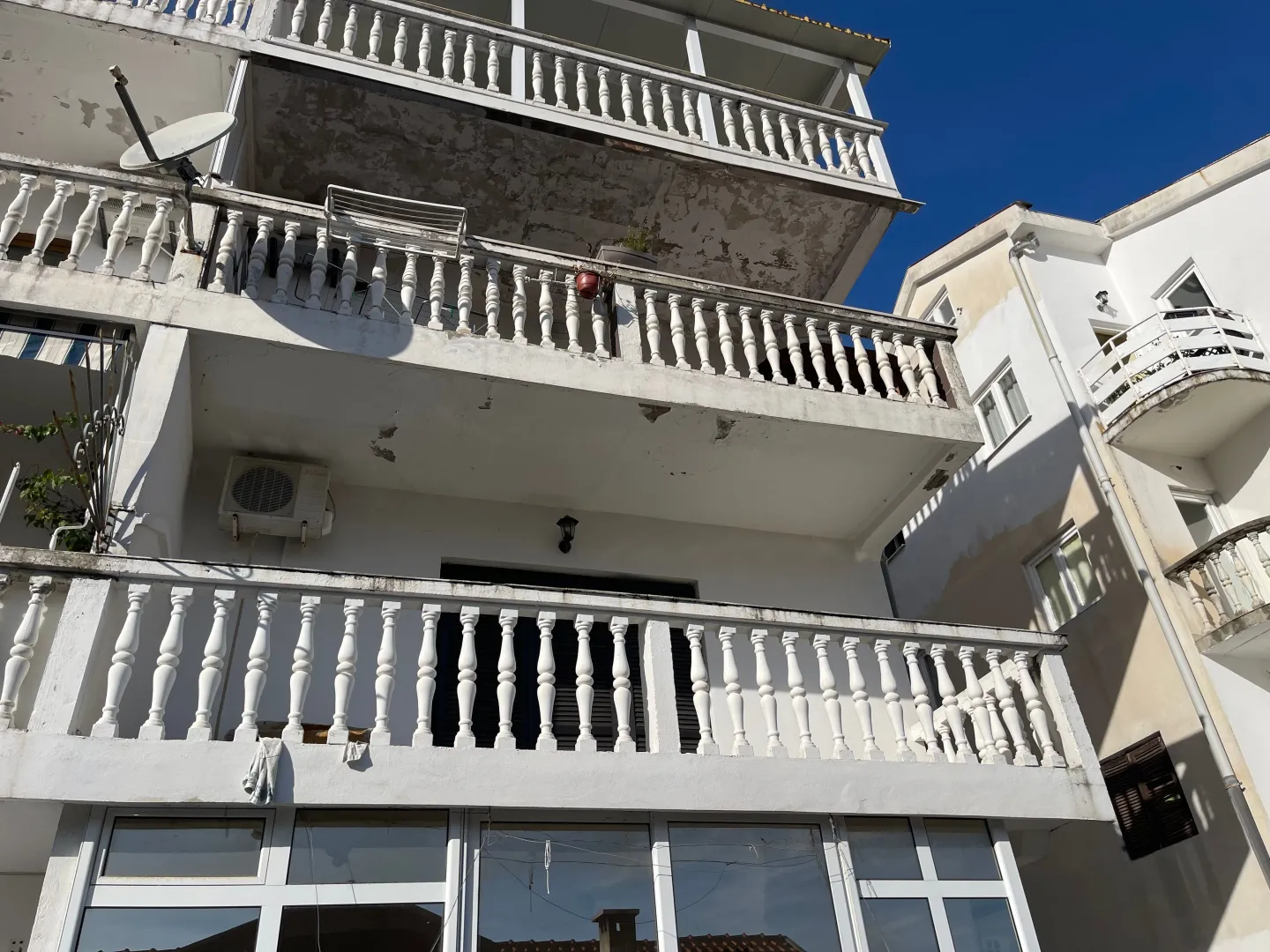 Spoljašnji izgled višespratne kuće sa terasama i balustradama.